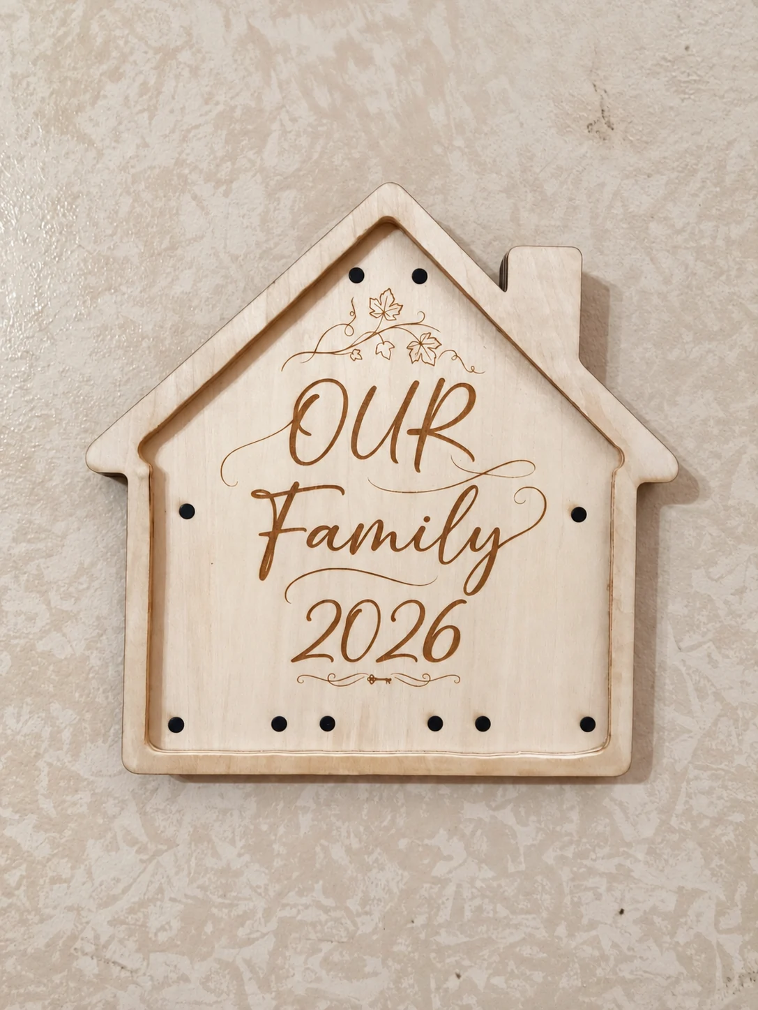Dettaglio della casetta in legno incisa Our Family 2026
